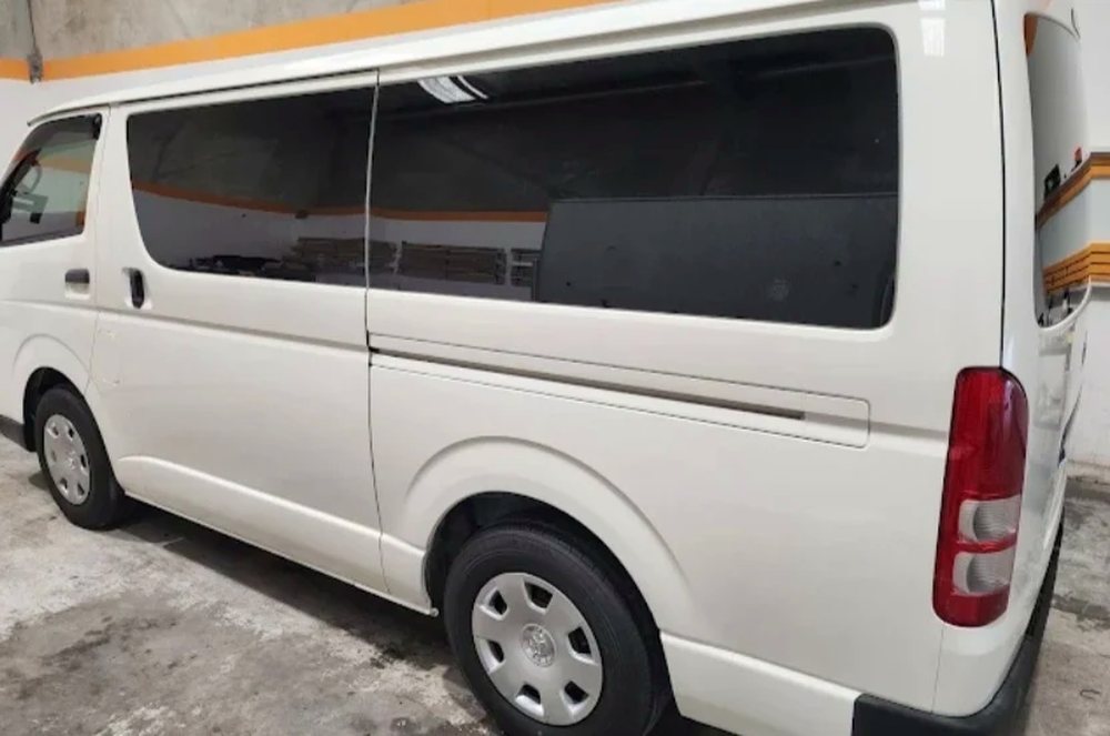 White Toyota HiAce van with tinted windows